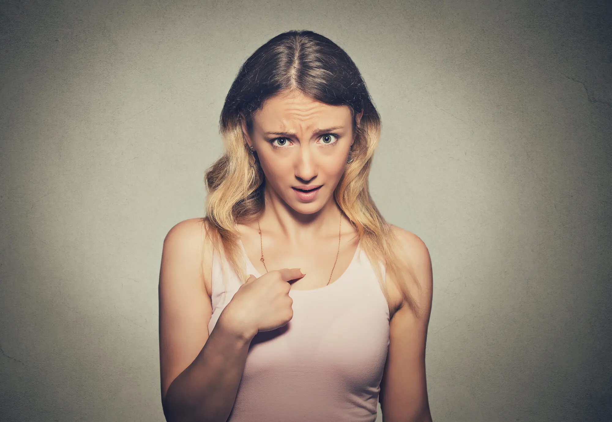Angry woman in a pink shirt pointing at herself