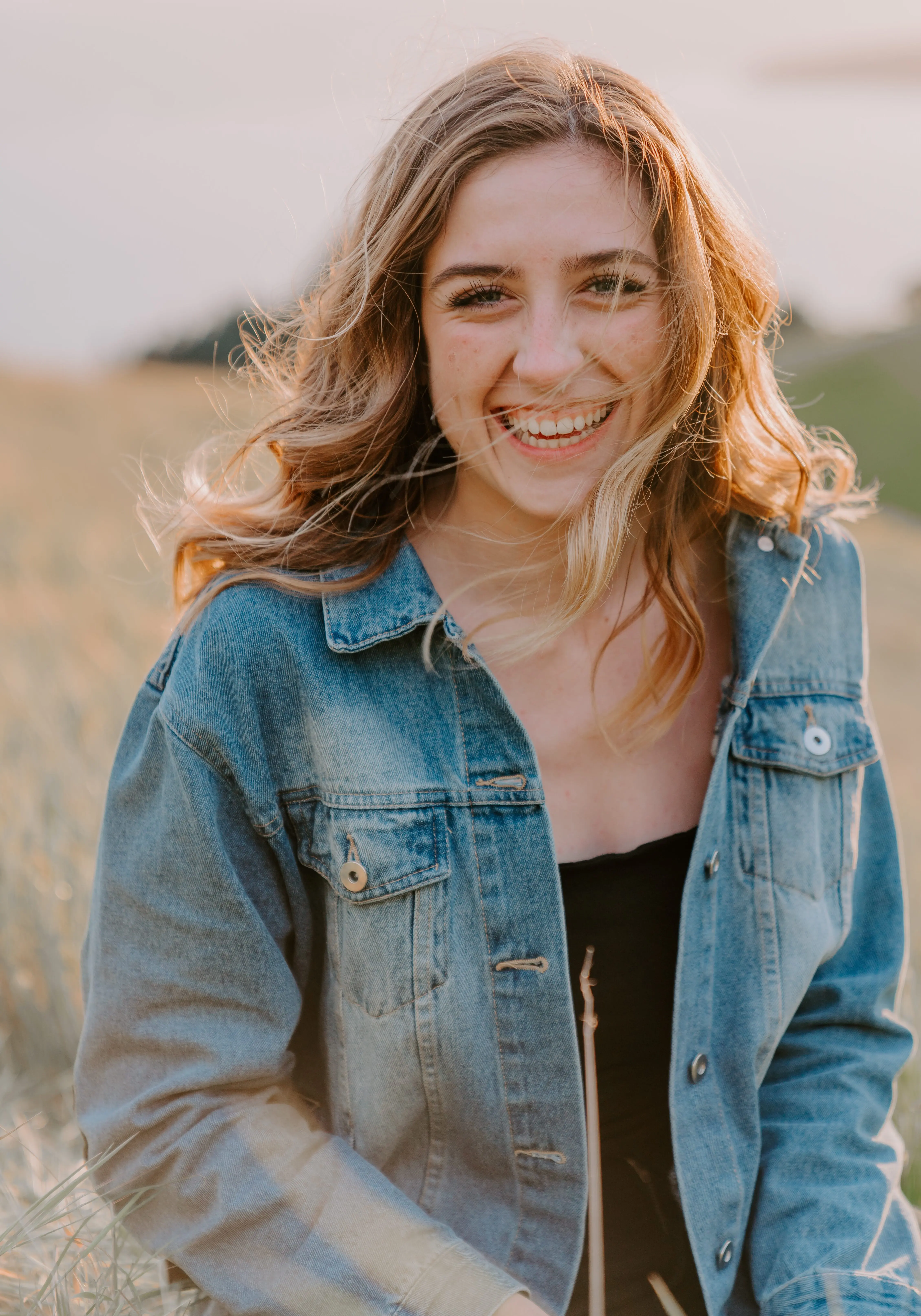 Smiling woman in a denim jacket outdoors