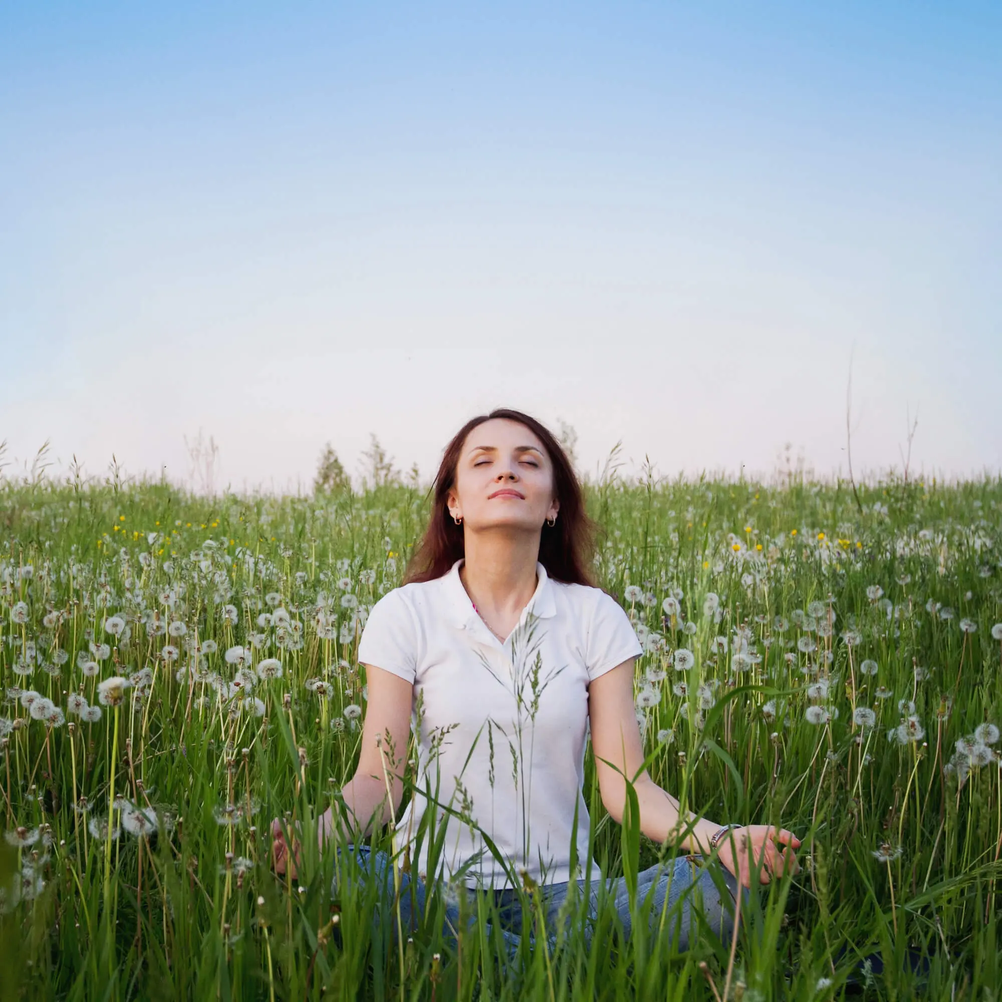 Woman sitting peacefully in a field